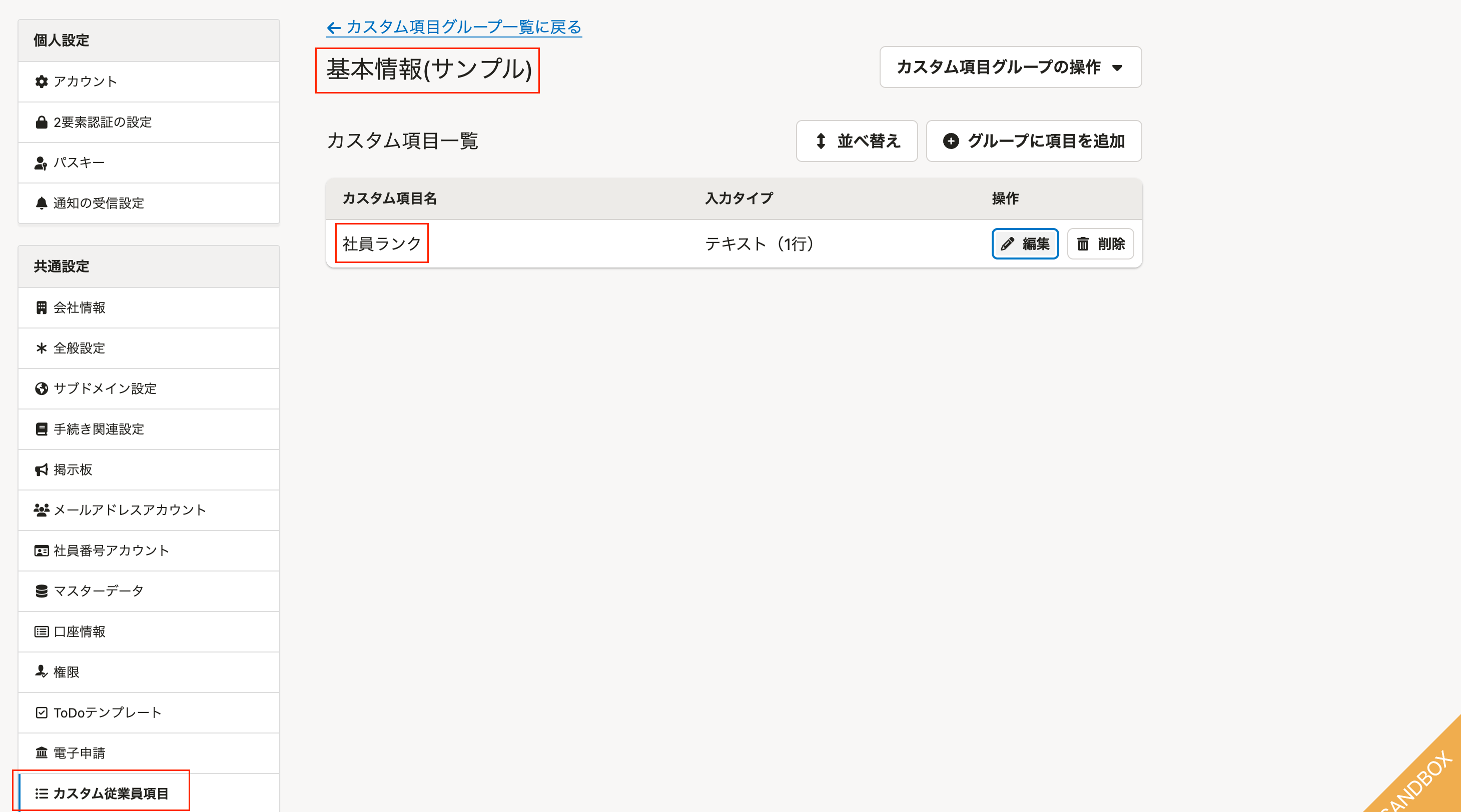 SmartHRの共通設定のカスタム従業員項目の画面。カスタム項目グループ「基本情報(サンプル)」に入力タイプがテキスト（1行）のカスタム項目「社員ランク」がある